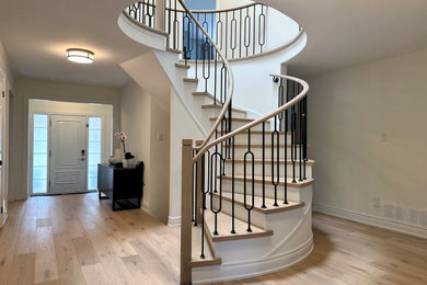 Staircase - contemporary wooden spiral metal railing staircase idea in Toronto with wooden risers