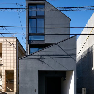 東京23区のコンテンポラリースタイルのおしゃれな三階建ての家 (グレーの外壁、片流れ屋根、戸建) の写真