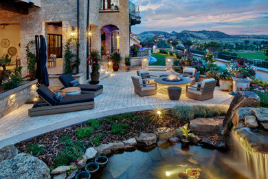 Inspiration for a mid-sized backyard stone patio remodel in Denver with a fire pit