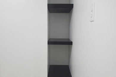 Built-in closet - small traditional built-in closet idea in Omaha with open cabinets