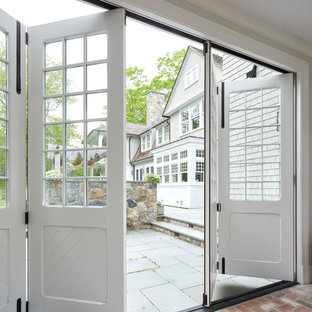 Idee per un corridoio classico con pareti grigie, pavimento in mattoni, una porta scorrevole, una porta bianca e pavimento rosa