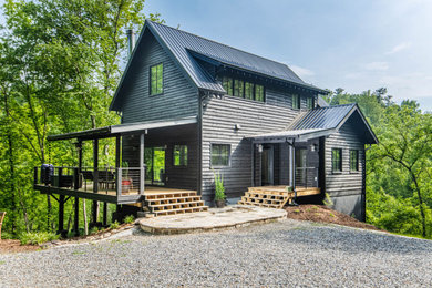 Rustic black three-story wood exterior home idea in Other with a metal roof