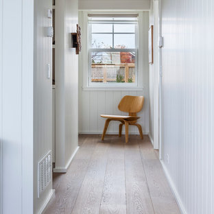 Inredning av en maritim hall, med vita väggar och mellanmörkt trägolv