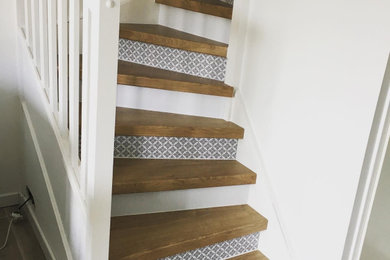 Idée de décoration pour un escalier courbe minimaliste de taille moyenne avec des marches en bois et un garde-corps en bois.