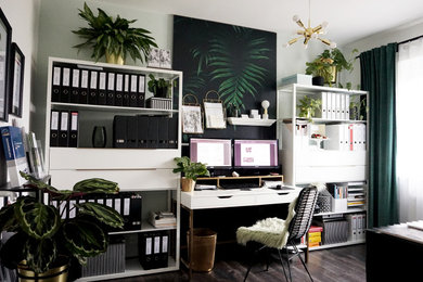 Diseño de despacho ecléctico de tamaño medio con paredes verdes, suelo laminado, escritorio independiente, suelo marrón y papel pintado