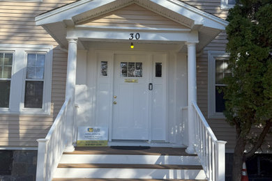Example of a mid-sized mid-century modern vinyl exterior home design in Boston