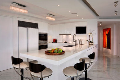 Inspiration for a large modern l-shaped kitchen in Miami with a double-bowl sink, flat-panel cabinets, white cabinets, stainless steel appliances, marble floors and a peninsula.