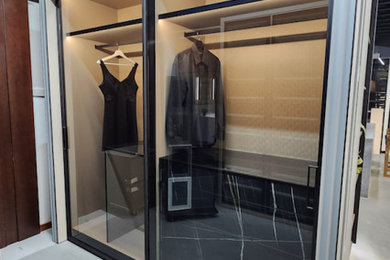 Ispirazione per un armadio incassato unisex minimalista di medie dimensioni con ante di vetro