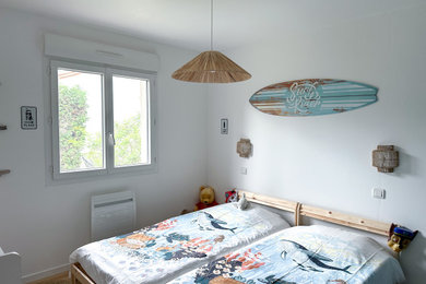 Aménagement d'une chambre d'enfant de 4 à 10 ans bord de mer de taille moyenne avec un mur blanc et un sol en contreplaqué.
