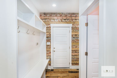 Mid-sized arts and crafts mudroom in Indianapolis with dark hardwood floors, a single front door, a white front door and wallpaper.