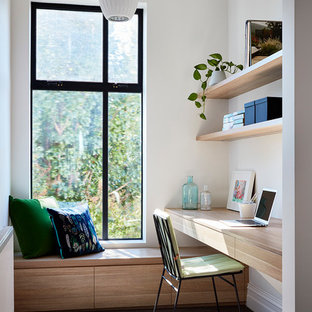 Foto på ett funkis arbetsrum, med vita väggar, heltäckningsmatta, ett inbyggt skrivbord och grått golv