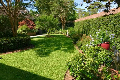 Photo of a mid-sized traditional backyard partial sun formal garden for summer in Charleston with a garden path and concrete pavers.