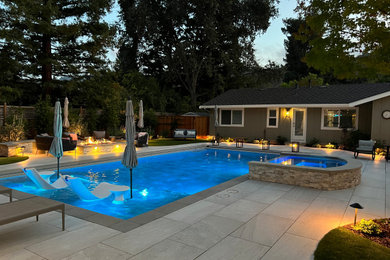 Immagine di una grande piscina monocorsia american style rettangolare dietro casa con piastrelle