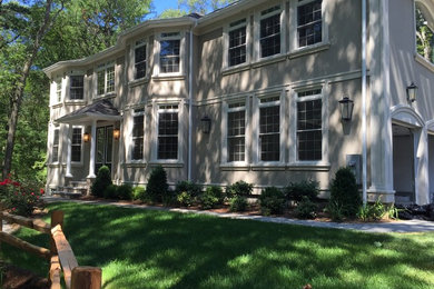 Example of a transitional beige stucco exterior home design in Boston
