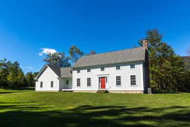 Photo of a large country two-storey white house exterior in Boston with wood siding, a gable roof and a shingle roof.