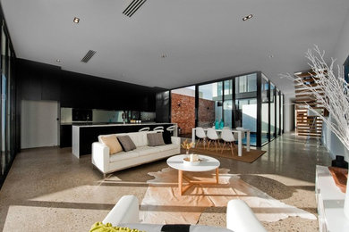 Large contemporary open concept living room in Adelaide with white walls, concrete floors and a wall-mounted tv.