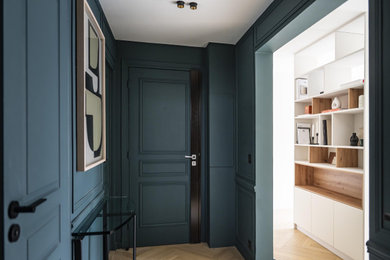 Cette photo montre une entrée tendance de taille moyenne avec un couloir, un mur bleu, parquet clair, une porte double, une porte bleue et un sol beige.