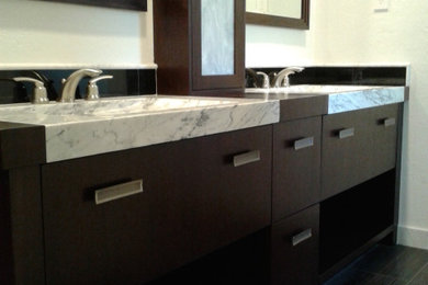 Trendy porcelain tile and double-sink bathroom photo in San Francisco with dark wood cabinets, an integrated sink, quartz countertops, white countertops and a built-in vanity