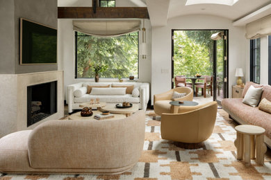 Living room - mid-sized modern medium tone wood floor, beige floor and exposed beam living room idea in Denver with white walls, a standard fireplace, a plaster fireplace and a wall-mounted tv