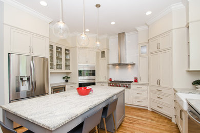 Eat-in kitchen - mid-sized transitional u-shaped light wood floor and brown floor eat-in kitchen idea in Atlanta with a farmhouse sink, beaded inset cabinets, white cabinets, granite countertops, white backsplash, ceramic backsplash, stainless steel appliances and an island
