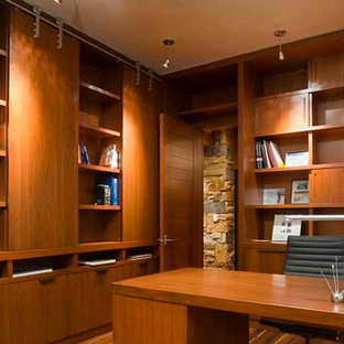 Modern study in Denver with medium hardwood flooring, a freestanding desk, beige walls, a corner fireplace and a stone fireplace surround.