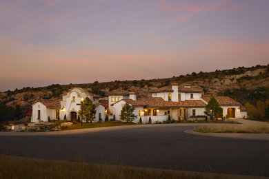 Large tuscan white two-story stucco exterior home photo in Denver