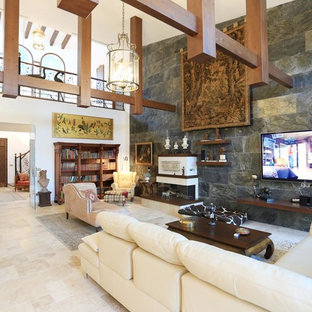 Inspiration for an expansive mediterranean open plan living room in Alicante-Costa Blanca with black walls, marble flooring, a standard fireplace, a wooden fireplace surround, a wall mounted tv and beige floors.