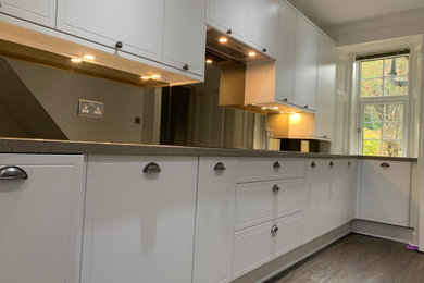 Imagen de cocina comedor minimalista sin isla con armarios estilo shaker, puertas de armario blancas y encimera de granito