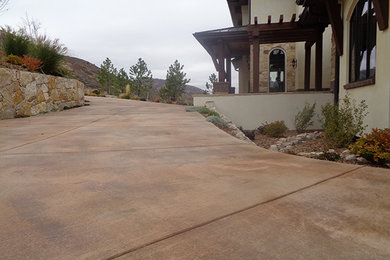 Photo of a large mediterranean front yard concrete paver driveway in Denver.