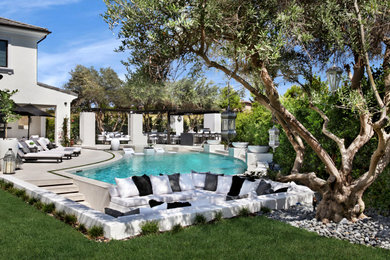 Inspiration for a large transitional beige two-story stucco house exterior remodel in Orange County