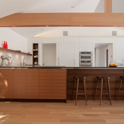 Inspiration for a large mid-century modern l-shaped marble floor, gray floor and vaulted ceiling kitchen remodel in Cleveland with a double-bowl sink, flat-panel cabinets, white cabinets, quartz countertops, yellow backsplash, ceramic backsplash, stainless steel appliances, a peninsula and gray countertops