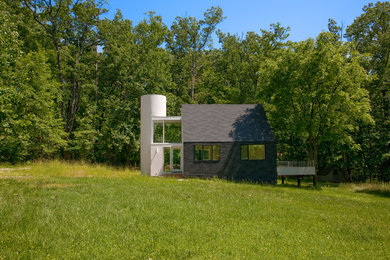 Small modern black one-story stucco gable roof idea in Baltimore