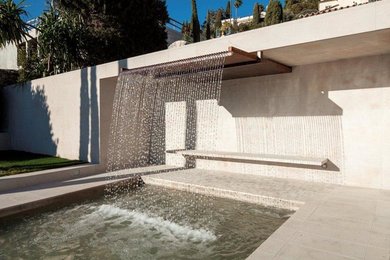 Mid-sized minimalist front yard stone and rectangular natural pool fountain photo in Nice