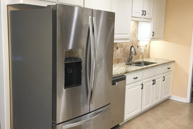 Eat-in kitchen - mid-sized transitional galley ceramic tile eat-in kitchen idea in Jackson with an undermount sink, raised-panel cabinets, white cabinets, granite countertops, brown backsplash, ceramic backsplash, stainless steel appliances and no island