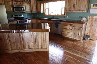 Mid-sized mountain style l-shaped medium tone wood floor eat-in kitchen photo in Other with a farmhouse sink, raised-panel cabinets, light wood cabinets, wood countertops, blue backsplash, stainless steel appliances, an island and brown countertops