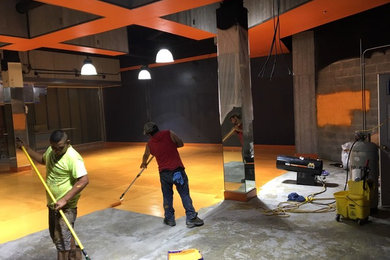 Indoor sport court - large modern concrete floor and orange floor indoor sport court idea in Atlanta with black walls