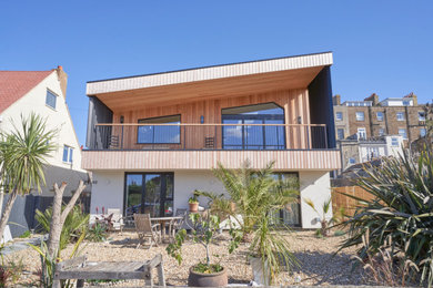 This is an example of a large scandinavian two floor front detached house in Kent with mixed cladding, a pitched roof and a grey roof.