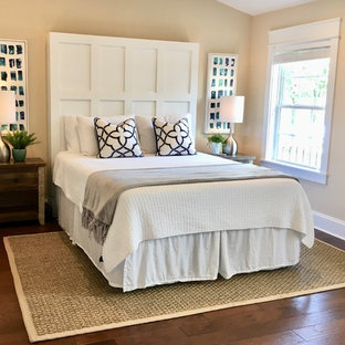 Photo of a mid-sized beach style master bedroom in Charlotte with yellow walls, medium hardwood floors and brown floor.