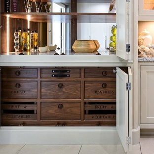 Mid-sized traditional kitchen pantry ideas - Example of a mid-sized classic single-wall kitchen pantry design in Berkshire with a drop-in sink, shaker cabinets, quartzite countertops, beige backsplash, stone slab backsplash, paneled appliances and no island