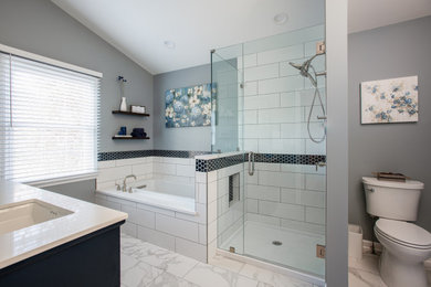Mid-sized transitional master white tile and subway tile porcelain tile, white floor and double-sink drop-in bathtub photo in Chicago with shaker cabinets, blue cabinets, a two-piece toilet, gray walls, an undermount sink, quartzite countertops, a hinged shower door, white countertops, a niche and a freestanding vanity