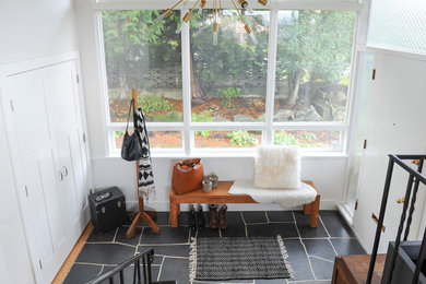 Inspiration for a mid-sized midcentury foyer in Vancouver with white walls, slate floors, a single front door, a white front door and black floor.