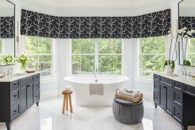 Example of a huge transitional master gray tile and marble tile marble floor, white floor and double-sink bathroom design in Charlotte with shaker cabinets, black cabinets, a one-piece toilet, blue walls, an undermount sink, quartzite countertops, a hinged shower door, white countertops and a freestanding vanity