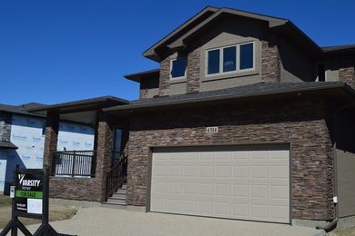 Example of a large classic brown two-story mixed siding gable roof design in Other