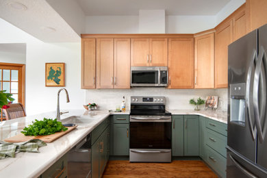 Design ideas for a mid-sized transitional u-shaped eat-in kitchen in Tampa with green cabinets, quartz benchtops, beige splashback, ceramic splashback, stainless steel appliances, a peninsula, brown floor, beige benchtop, an undermount sink, shaker cabinets and medium hardwood floors.