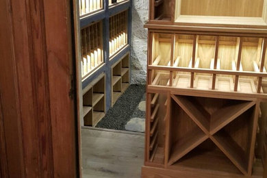 This is an example of a small classic wine cellar in Other with light hardwood flooring and display racks.