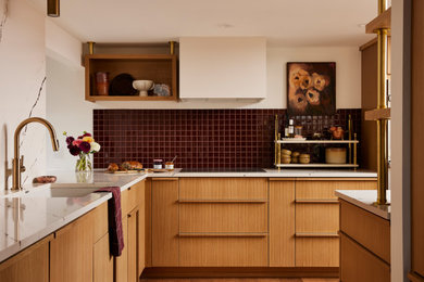 Inspiration for a mid-sized 1950s medium tone wood floor kitchen remodel in Minneapolis with a single-bowl sink, flat-panel cabinets, quartz countertops, red backsplash, ceramic backsplash, paneled appliances and a peninsula