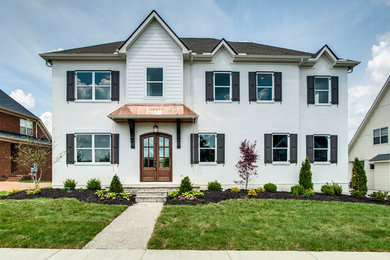 Large transitional white two-story brick exterior home idea in Nashville with a hip roof