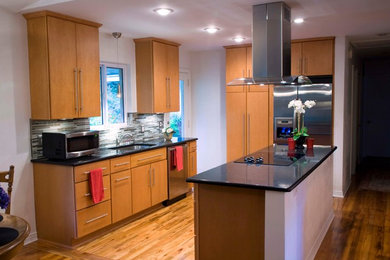 Mid-sized trendy galley medium tone wood floor open concept kitchen photo in Atlanta with an undermount sink, flat-panel cabinets, light wood cabinets, quartz countertops, gray backsplash, glass sheet backsplash, stainless steel appliances and an island