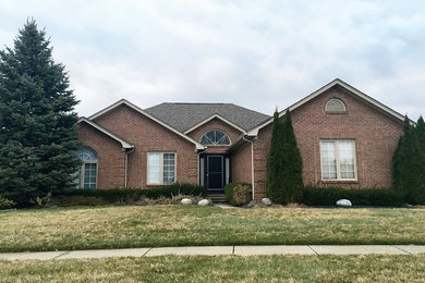 Mid-sized traditional red one-story brick house exterior idea in Detroit with a hip roof and a shingle roof