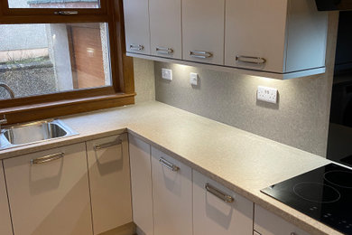 This is an example of a medium sized contemporary kitchen in Other with a single-bowl sink, flat-panel cabinets, laminate countertops, stainless steel appliances and beige worktops.